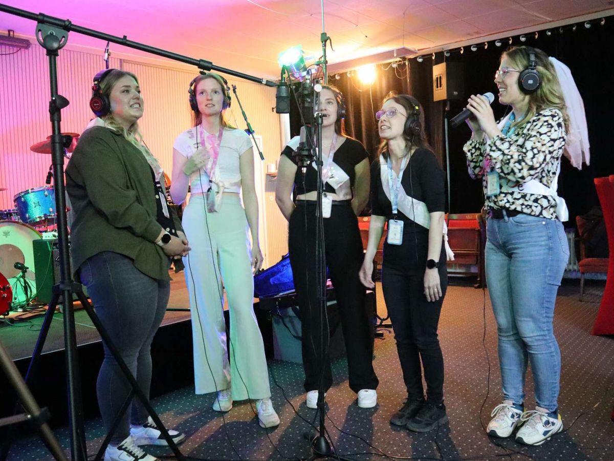 Frauen Gruppe singt in ein Mikrofon